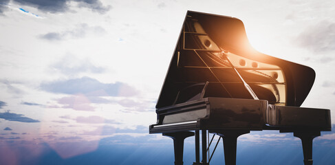 Grand piano on sunset sky background