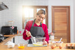 © peerasin - Asian chef woman blend dough and chocolate with beater for cooking chocolate cake with happy feeling in the morning