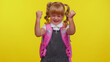 © Andrii Iemelianenko - Cheerful smiling school girl raising fists in gesture I did it, celebrating success, winning, goal achievemen isolated on yellow background wall with copy space for promotion content. Back to school