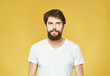 © SHOTPRIME STUDIO - emotional man in a white t-shirt hand gestures anger yellow background