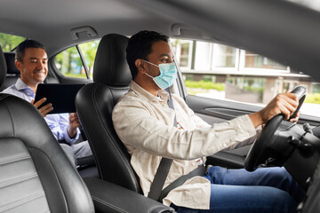 Wall Mural - transportation, health and people concept - indian male taxi driver driving car with passenger wearing face protective medical mask for protection from virus disease