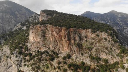 Wall Mural - View of antique rock burial chambers in ancient Lycian city of Pinara in Turkey. Examples of ancient rock cut architecture 