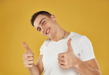 Wall Mural - Cheerful man gesturing with hands in white t-shirt cropped view isolated background