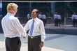 © DragonImages - Smiling mature businessman greeting his international business partner and shaking his hand
