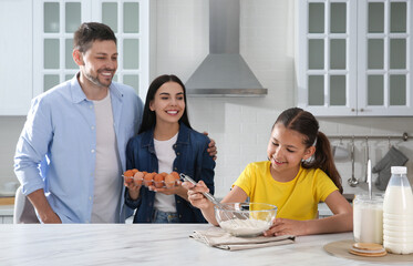 Wall Mural - Happy family cooking together at table in kitchen. Adoption concept