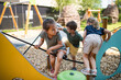 © Halfpoint - Group of small nursery school children playing outdoors on playground.