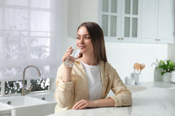 Canvas Print - Woman drinking tap water from glass in kitchen