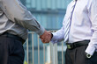 © DragonImages - Close-up image of business people in grey and lavender shirts shaking hands when greeting each other before negotiations