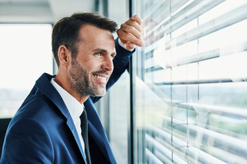 Poster - Successful businessman looking outside office window