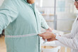 © AnnaStills - Close-up of doctor measuring waist of overweight man during his visit to the hospital