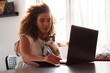 © Stock Rocket - A young girl sits in the home office with her cat and uses a laptop for e-classes.