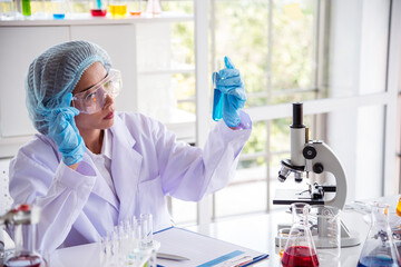 Closeup Woman scientist hand use dropper in lab look at science microscope medical test, research biology chemistry. Females technician laboratory analyzing blood scientific pharmaceutical research.