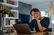 © bnenin - Tired businesswoman working on laptop.