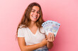 © Asier - Young caucasian woman holding bills isolated on pink background  laughing and having fun.