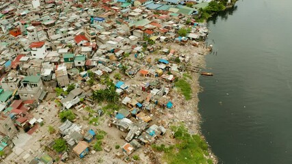 Wall Mural - Slums in Manila on the bank of a river polluted with garbage, aerial view.