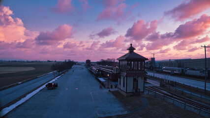 Wall Mural - Sunrise With Blue, Red Sky and Clouds Looking Over a Train Station and Yard