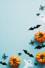 Happy Halloween Holiday Concept. Frame Of Halloween Decorations, Bats, Ghosts, Pumpkins, Spiders On Blue Background. Halloween Party Invitation Card Mockup With Copy Space. Flat Lay, Top View.
