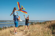 © Andrii - Happy family in nature launch a kite into the sky