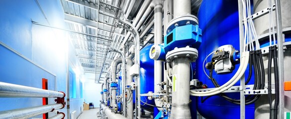Large blue tanks in a industrial city water treatment boiler room. Wide angle perspective