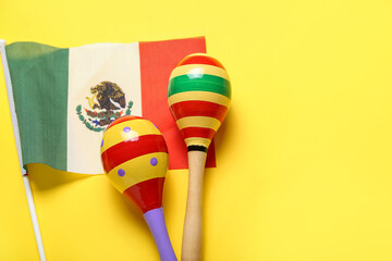 Mexican flag and maracas on color background