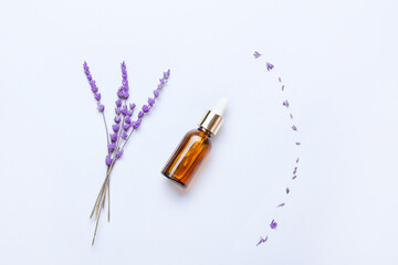 Wall Mural - Composition with bottle of lavender essential oil and flowers on light background