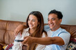 © simona - Young interracial couple watching tv together sitting on the sofa at home - couple life and happy lifestyle people having with movie - indoor leisure activity black boy and caucasian girl in love