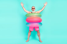 Photo Of Crazy Old Man Enjoy Fun Raise Hands Wear Lifebuoy Sunglass Shorts Isolated Turquoise Color Background