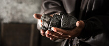 Coal Mining : Coal Miner In The Man Hands Of Coal Background. Picture Idea About Coal Mining Or Energy Source, Environment Protection. Industrial Coals Holding On Hands. Volcanic Rock. Panorama Photo