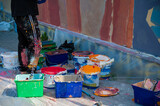 Fototapeta Paryż - A street artist paints on the wall. close-up of paint buckets.