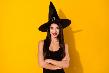 Photo of lovely witch millennial lady crossed arms wear black dress cap isolated on yellow color background