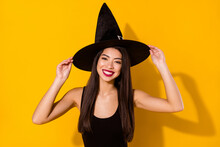 Photo Of Optimistic Funny Witch Lady Touch Cap Wear Black Dress Isolated On Yellow Color Background