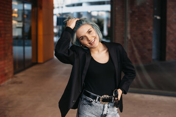 Beautiful portrait of blue haired businesswoman. Pretty young woman. Stylish person posing outside.