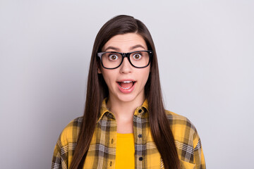 Poster - Photo of cute impressed young woman dressed checkered shirt glasses smiling open mouth isolated grey color background