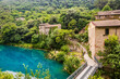 A glimpse of the small village of Stifone, on the Nera river. Umbria, Terni, Italy. The walls of stones and bricks. The bridge over the river with clear blue waters. Tourists stroll through the alleys