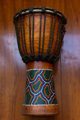 Djembe music instrument isolated over brown wooden background