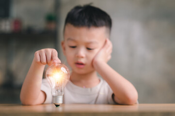 Poster - Boy kid Child with a bright light bulb. Concept of Ideas for presenting new ideas Great inspiration and innovation new beginning.