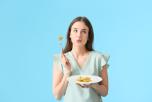 Beautiful Young Woman Eating Tasty Ravioli On Color Background