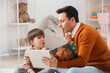 © Pixel-Shot - Speech therapist with little boy reading book in office