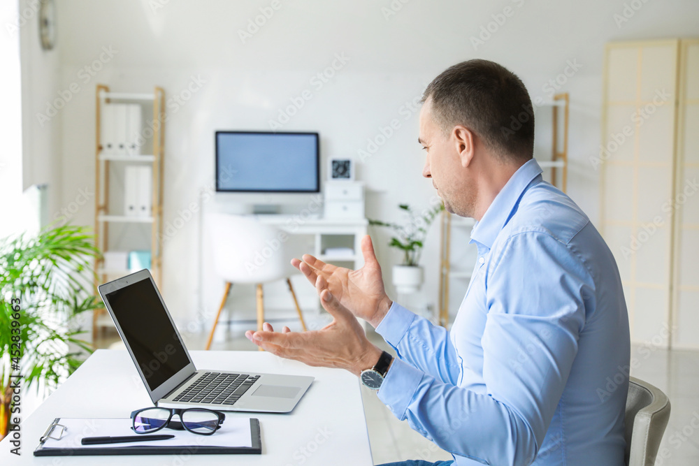 Mature man video chatting in office