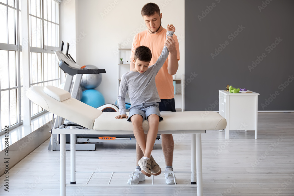 Physiotherapist working with boy in rehabilitation center