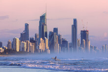 Surfers Paradise Cityscape, With Surfer Going Into The Ocean