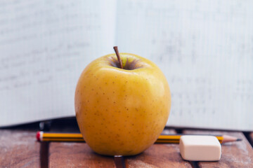 books, pencil sharpener, pencil and apple on the table, back to school concept