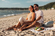 © Syda Productions - leisure, relationships and people concept - happy couple having picnic on beach