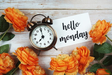 Poster - Hello Monday card and alarm clock with orange flower decoration on wooden background