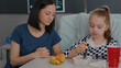 © DC Studio - Hospitalized sick daughter recovering after medical surgery eating healthy lunch nutrition resting in bed. Mother sitting beside little kid having food meal breakfast in hospital ward