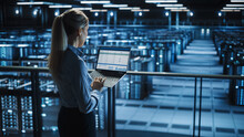 Data Center Female IT Specialist Uses Laptop Computer. Cloud Computing Server Farm With IT Engineer Monitoring Statistic, Maintenance Control. Information Technology Of Fintech, E-Business.