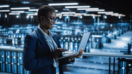 Wall Mural - Data Center Female Programmer Using Laptop Computer, Maintenance IT Specialist. In Cloud Computing Server Farm Smiling System Administrator Working on Cyber Security for Iaas, saas, paas.