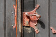 Altes rötliches Türschloss mit Türklinke an einem alten Holztor, Deutschland