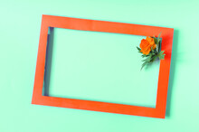 Orange Paper Frame Decorated With An Orange Flower On A Colored Background. Flat Bright Pink Photo Frame And Flower Decor.