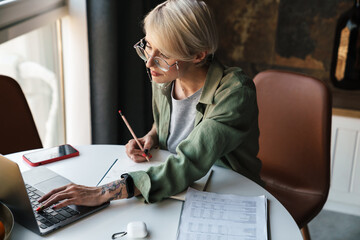 Canvas Print - Middle aged blonde woman with short hair studying